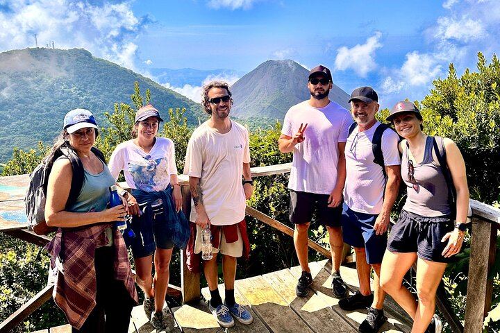 a group of friends are posing in front of izalco volcano