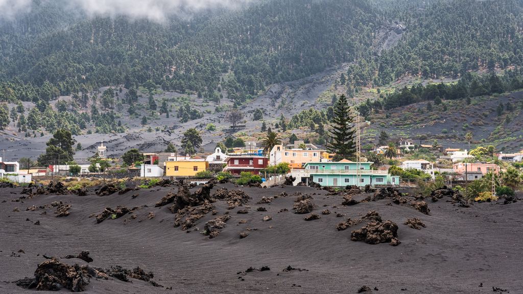 Intact houses of a La Palma town immediately beside the black lava field left by the 2021 eruption