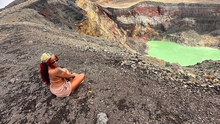 A traveler is posing in front of the santa ana volcano crater