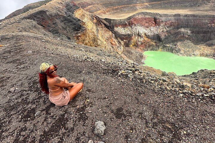 A traveler is posing in front of the santa ana volcano crater