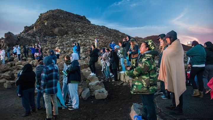 Blankets and beanies warm a group of onlookers atop Mount Haleakala, Maui where temperatures drop considerably.
