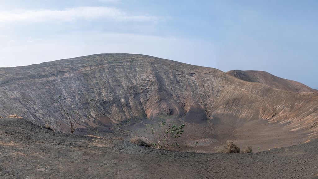 Walkers on the rim of the Caldera Blanca volcano near Timanfaya, Lanzarote