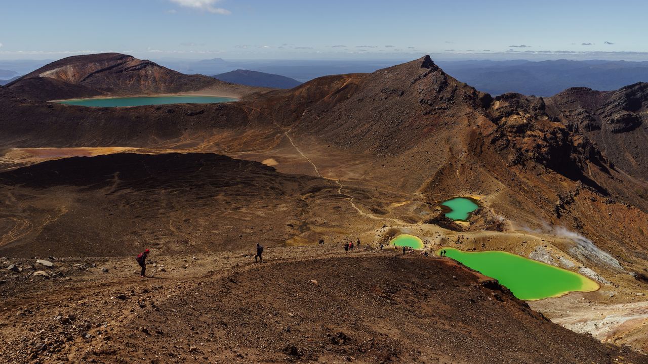 Walkers' view over the Emerald Lakes and the volcanic landscape of the Tongariro Alpine Crossing, New Zealand