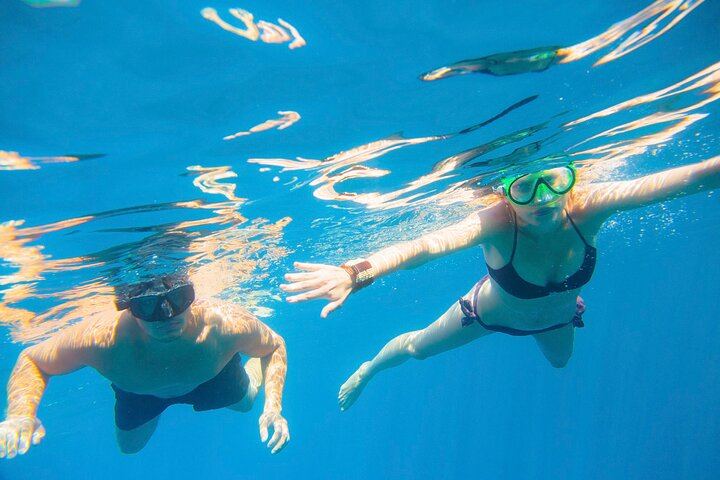 Enjoy with your friends snorkeling in clear blue water, observing the underwater world with masks, snorkels, and fins.