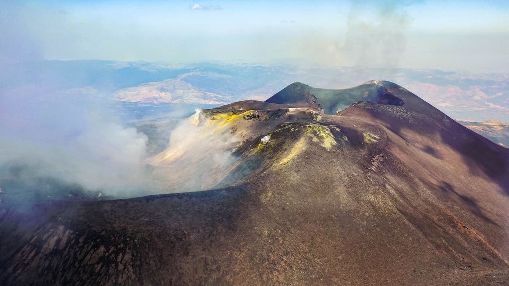 Aerial view of Mount Etna's summit craters with gas venting from the rim