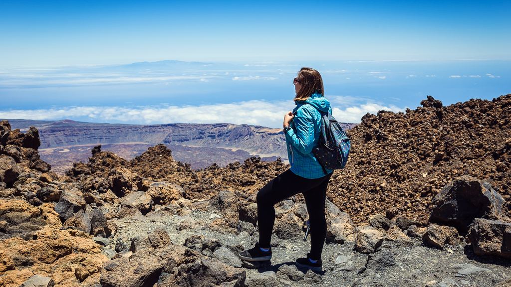 A hiker standing above a sea of cloud on the upper slopes of the Teide volcano, Tenerife