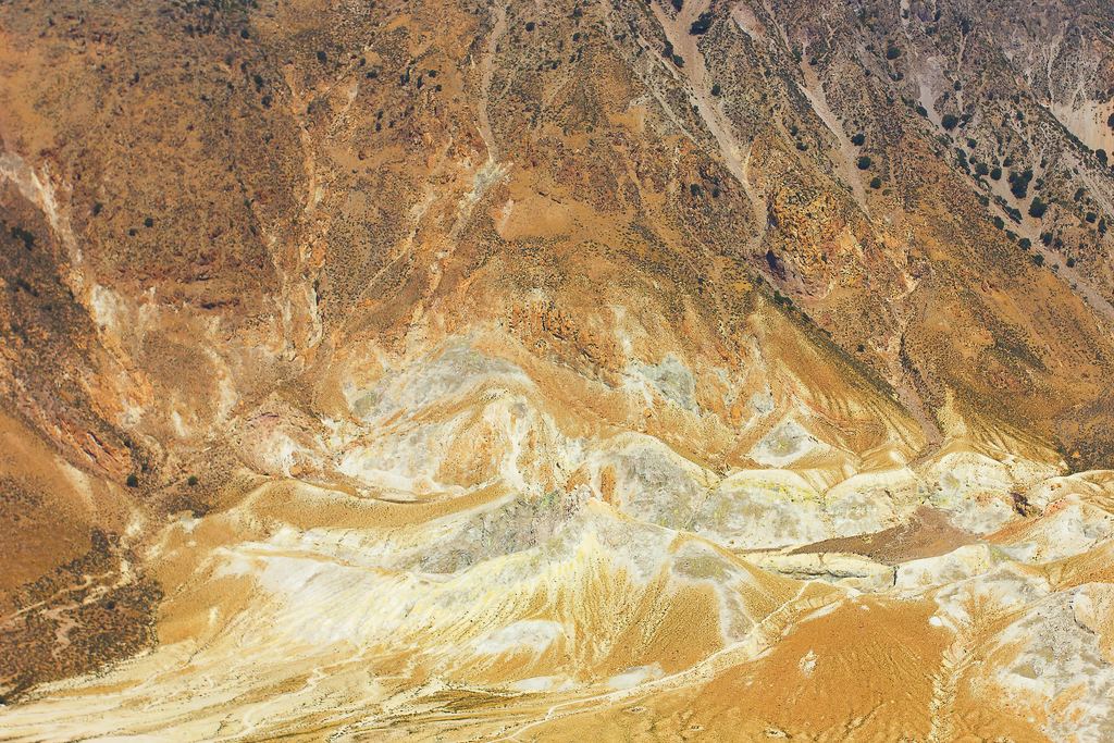 Sulphur-stained ground inside the Nisyros volcano caldera, Greece