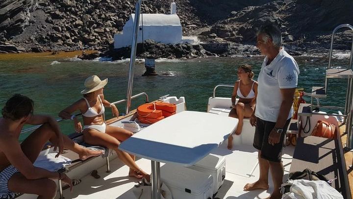 Our boat tour stops near the coast of Palia Kameni, the volcanic island in Santorini, for people to swim in the natural, sulfur-rich hot springs. The water is warm and orange-tinted.