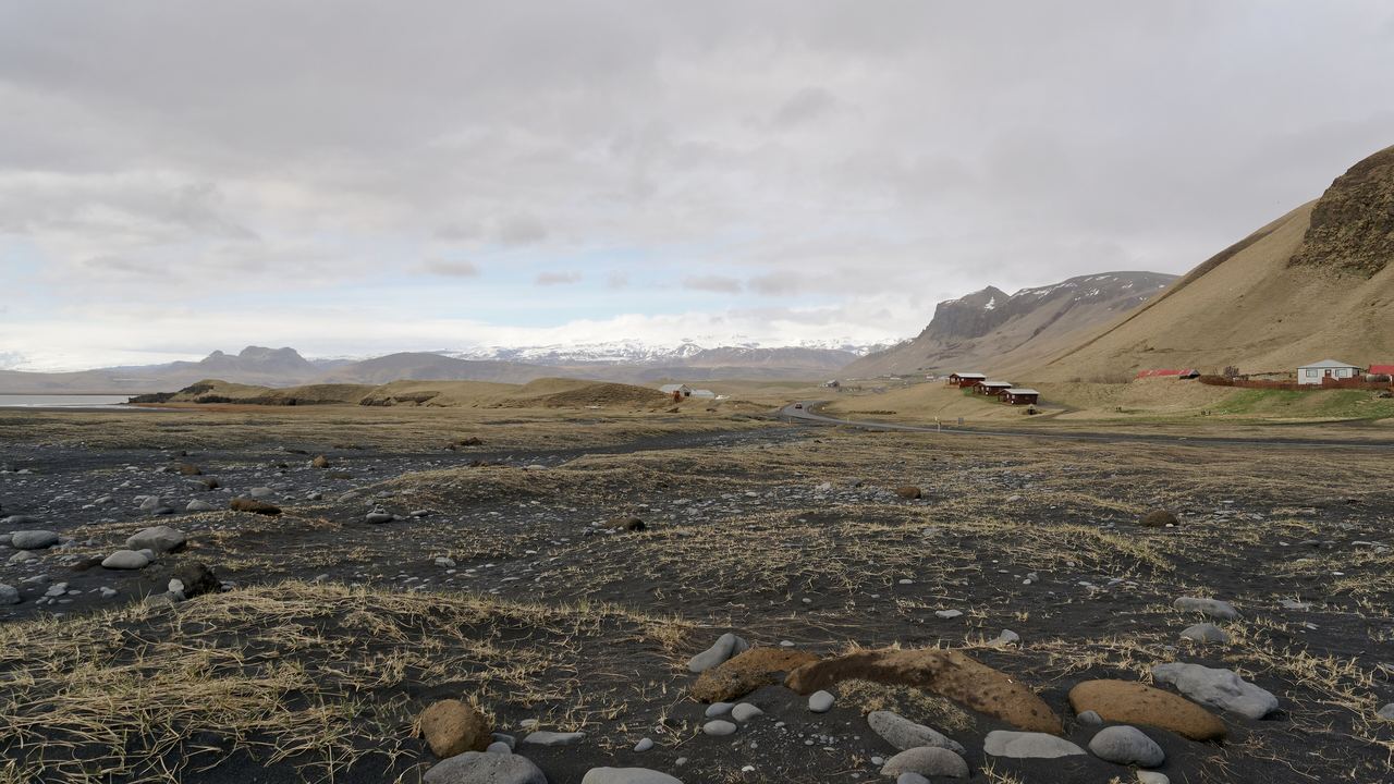 The black sand of Reynisfjara near Vík with the Mýrdalsjökull ice cap, which covers the Katla volcano, on the skyline behind