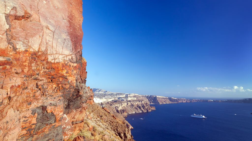 The layered volcanic cliff of the Santorini caldera dropping to the sea