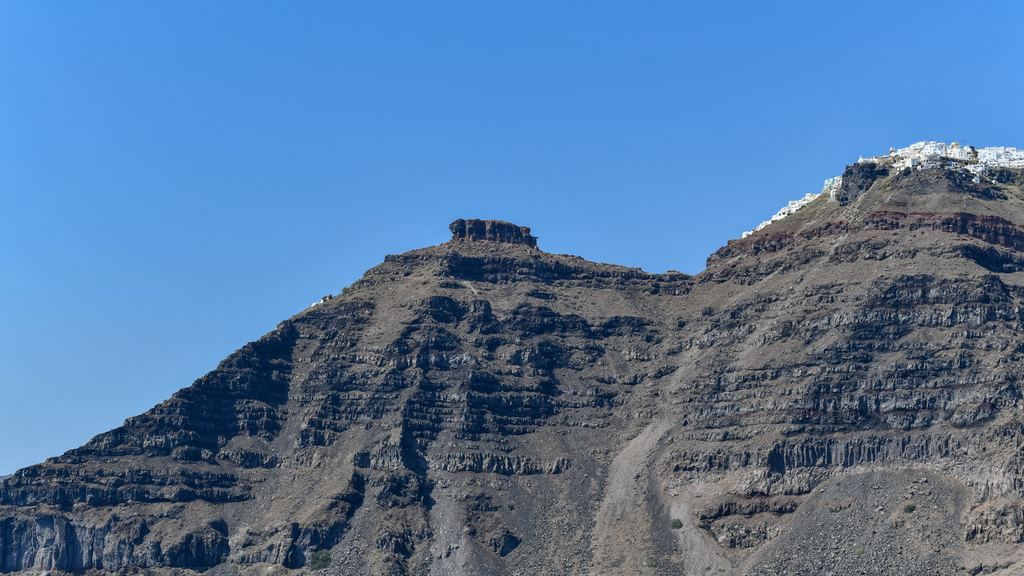 The cliffs of Santorini seen across the water from the volcanic island of Nea Kameni