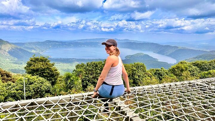 Solo female traveler posing in fron of the Coatepeque Lake