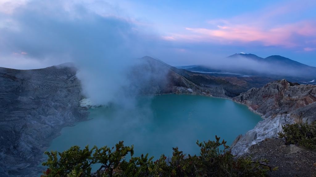 Thick sulphurous smoke rising from vents beside the acid lake in the Ijen crater