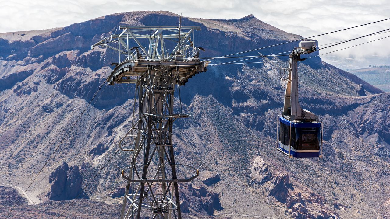 A cable car cabin climbing above the bare volcanic slopes of Mount Teide towards the upper station on Tenerife