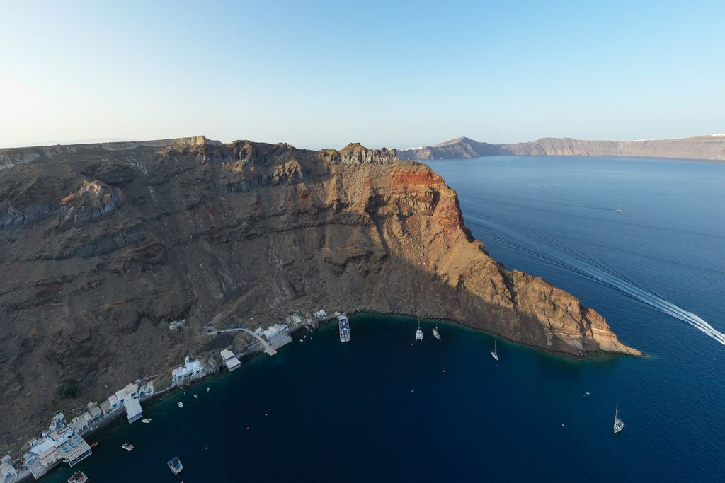 The layered caldera cliffs of Thirassia across the water from Santorini, Greece