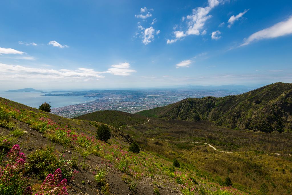 The bare volcanic gravel of Mount Vesuvius with the Bay of Naples behind