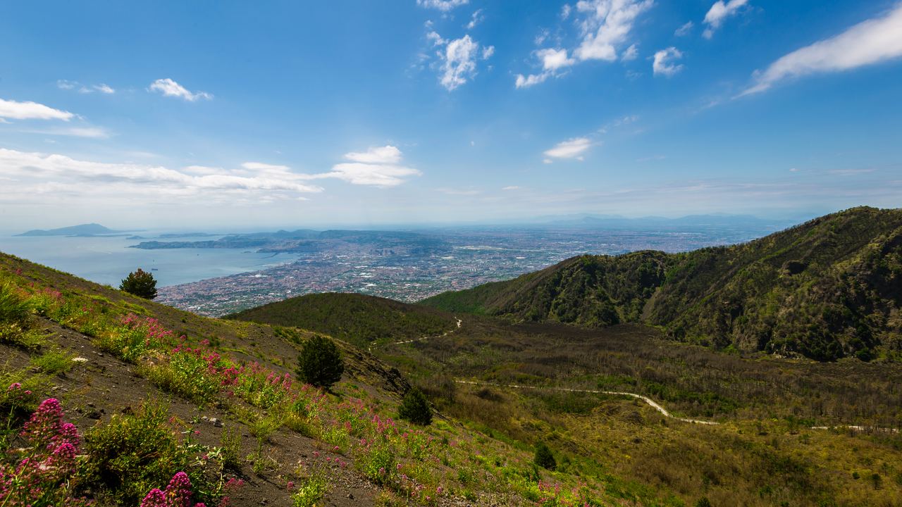 The bare volcanic gravel of Mount Vesuvius with the Bay of Naples behind
