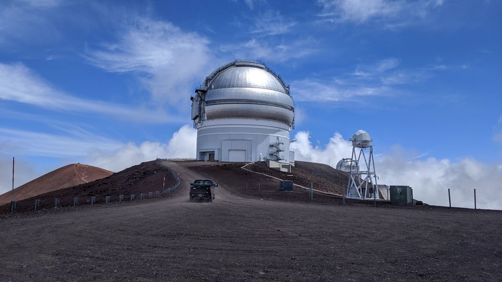 The access road and bare volcanic cinder near the summit of Mauna Kea above the clouds