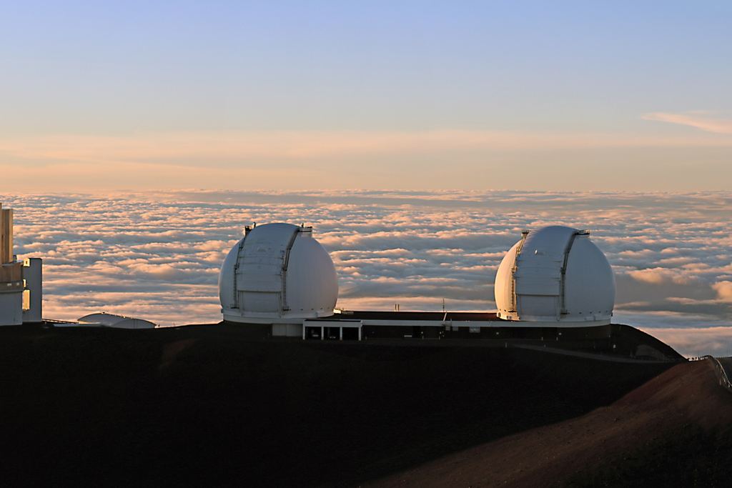 The Subaru telescope and the twin Keck domes standing on the red cinder of the Mauna Kea summit, Hawaiʻi