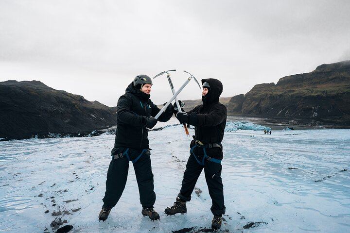 Travelers share smiles and panoramic views while exploring Sólheimajökull on a guided glacier hiking tour in South Iceland