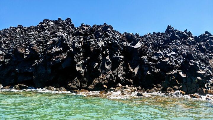 Visit Palia Kameni, the volcanic island in Santorini. This is where you can see unique formations of frozen black lava rocks along the coast