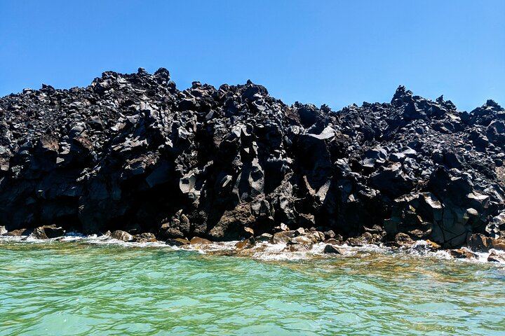 Visit Palia Kameni, the volcanic island in Santorini. This is where you can see unique formations of frozen black lava rocks along the coast