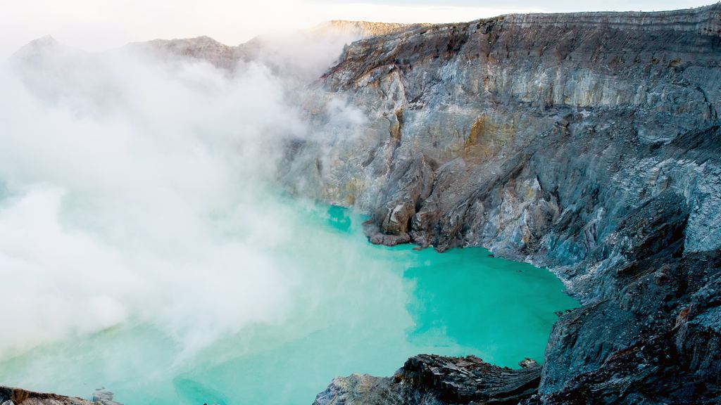 Yellow sulphur deposits on the crater floor above the blue acid lake of the Ijen caldera